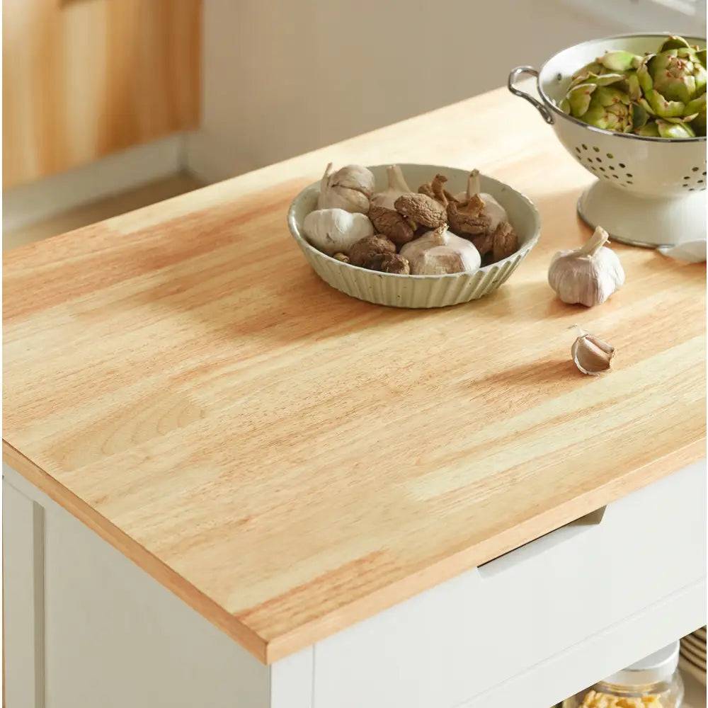 Sobuy kjøkkenøy med lys trebenkeplate, grønn bolle med sopp og hvitløk, dørslag med grønnsaker bak.