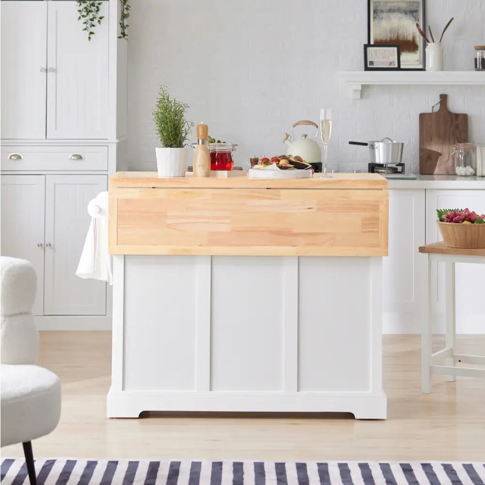 SoBuy kjøkkenøy med lys treplate, urter og kjøkkenredskaper på toppen, stripete teppe foran.