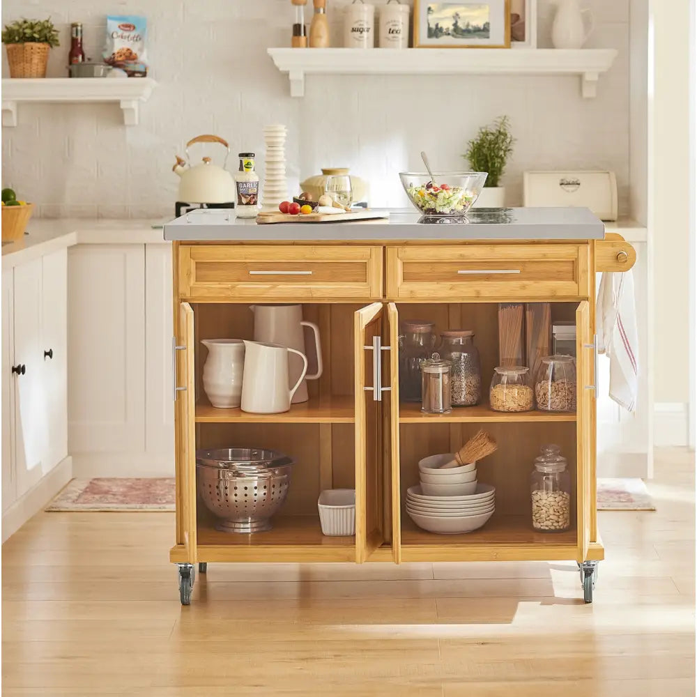 Sobuy kjøkkenøy i lyst tre med grå topp, åpne skapdører viser servise og mat, hjul for mobilitet.