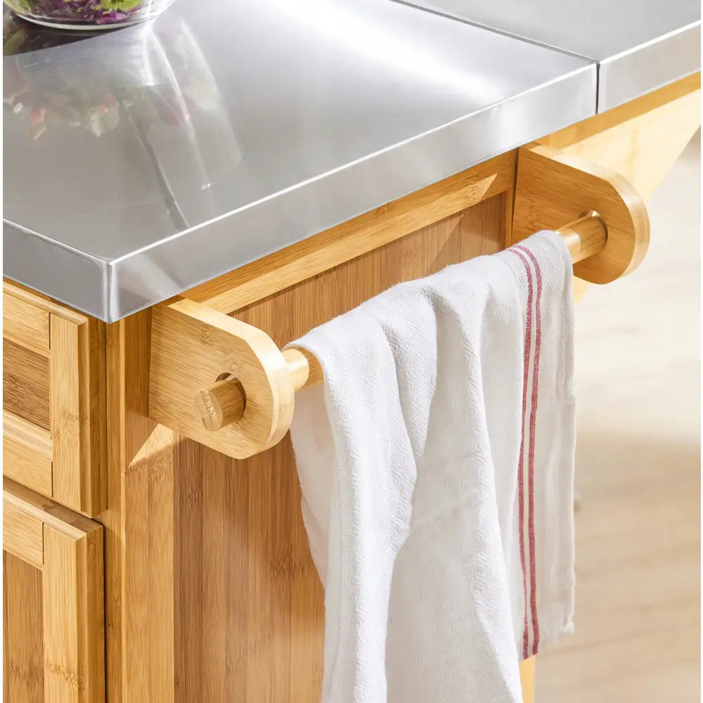 Sobuy kjøkkenøy med stålbenkeplate, detalj av trehåndtak med kjøkkenhåndkle med røde striper.