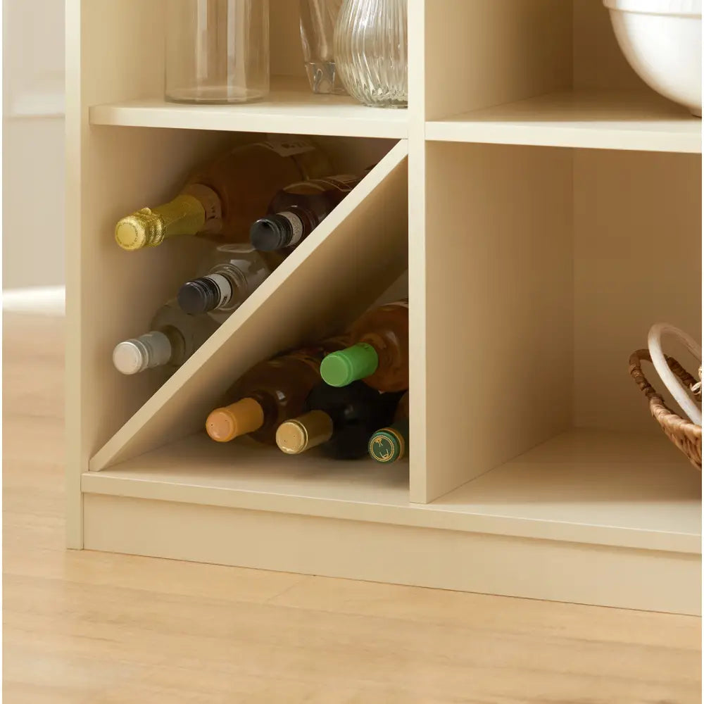 Kjøkkenøy med kremfarget hylle, nærbilde av trekantet vinrom fylt med flasker med fargerike korker.