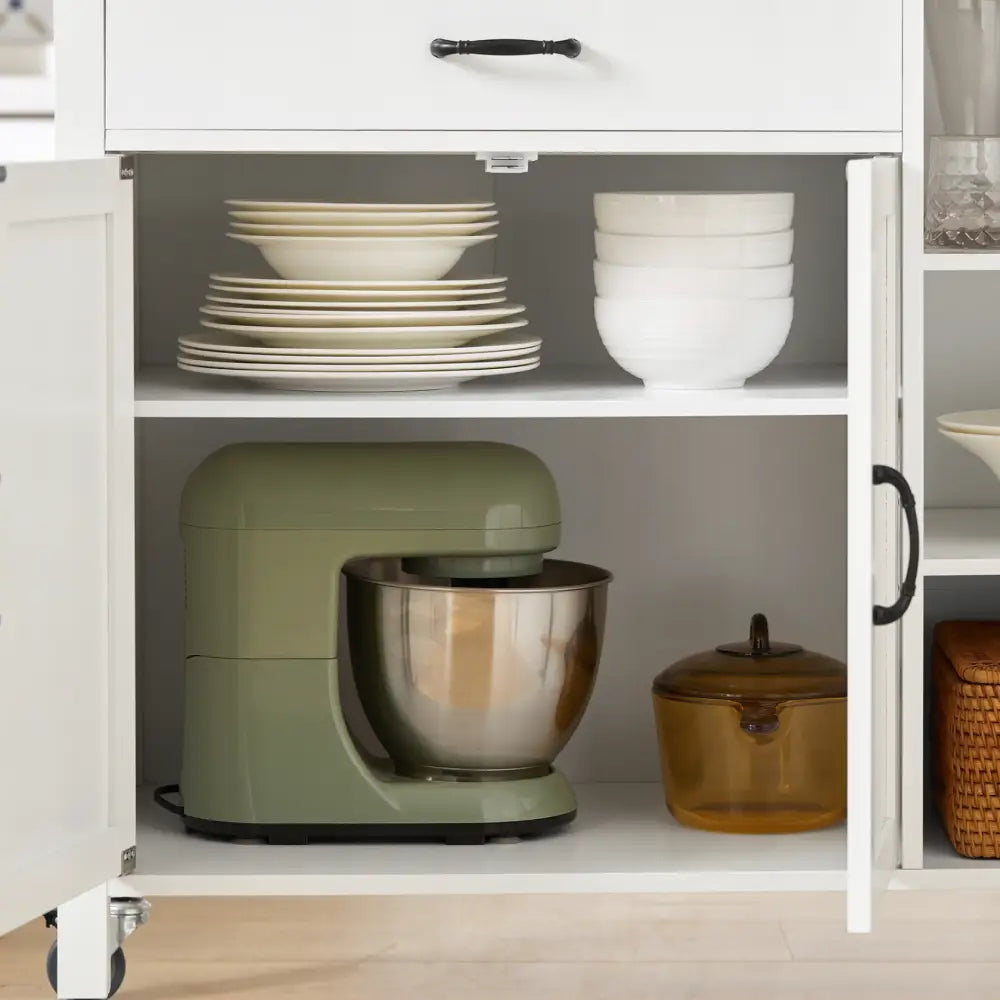 Sobuy kjøkkenøy med hvitt skap, grønn kjøkkenmaskin og brun glassbolle foran, servise på hylle over.