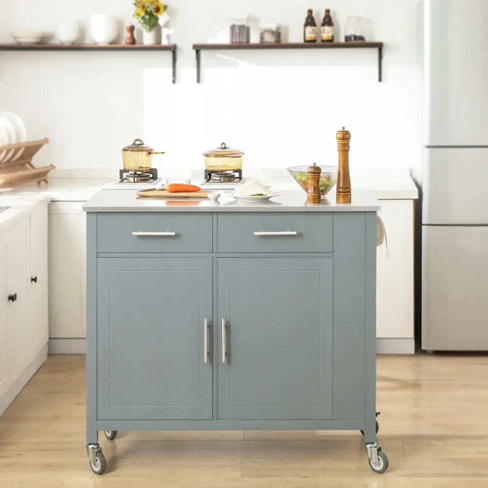 Sobuy kjøkkenøy i lys blått treverk, to skuffer og skapdører, hvit topp og hjul, frontvisning.