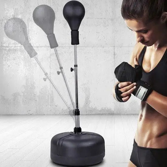 Stående boksebag med pære, justerbar modell med rund sort base, vist sammen med kvinne som tar på boksehansker.