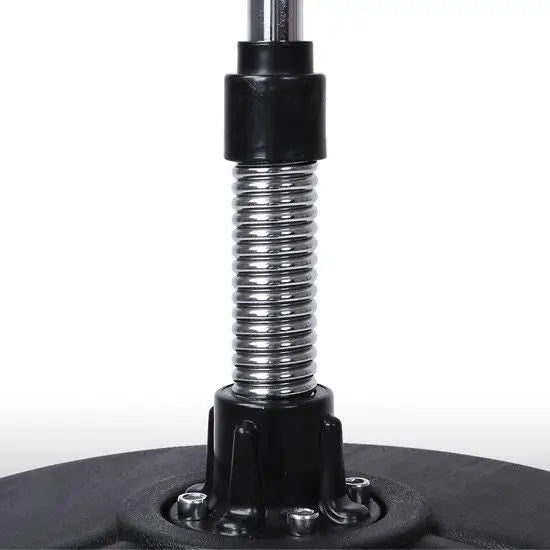 Kraftig sølvfarget metallfjær på sort plastbase med fire skruer, nærbilde av boksebagens feste.