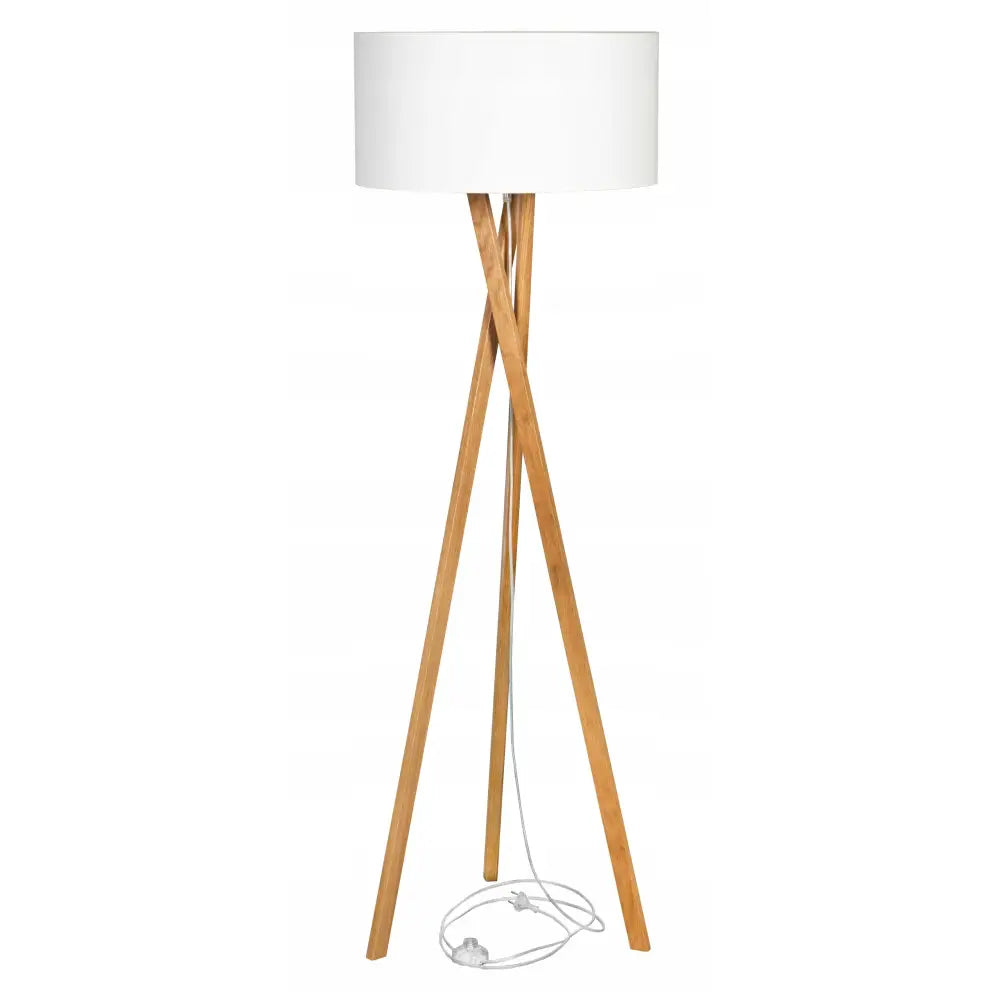 Stående gulvlampe med hvit sylinderformet skjerm og eikefargede tripod-ben, sett rett forfra.