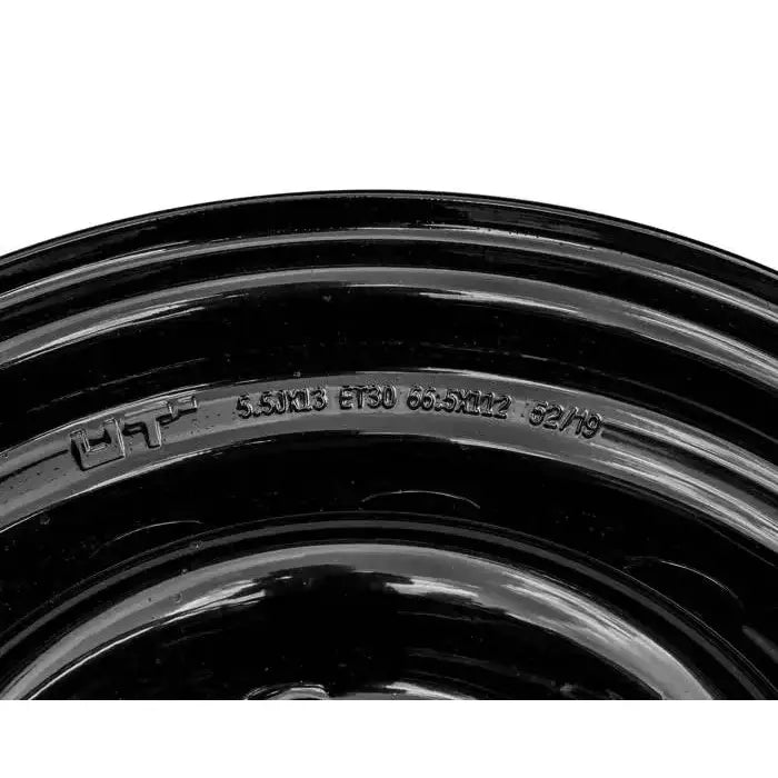 Stålfelg til hengere, nærbilde fra skrå vinkel med fokus på inngravert tekst og tekniske detaljer.