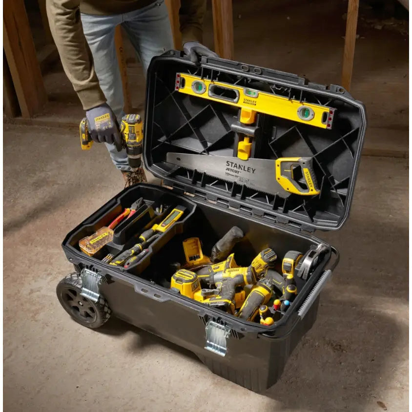 Stanley verktøykasse på hjul 113L, åpen og fylt med verktøy med gule detaljer, sett ovenfra på arbeidsplass.