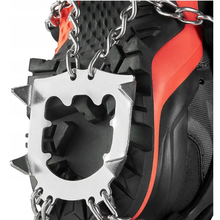 Stegjern med 13 tagger festet til sort og oransje fjellsko, nærbilde av kraftige stålpigger og kjettinger.