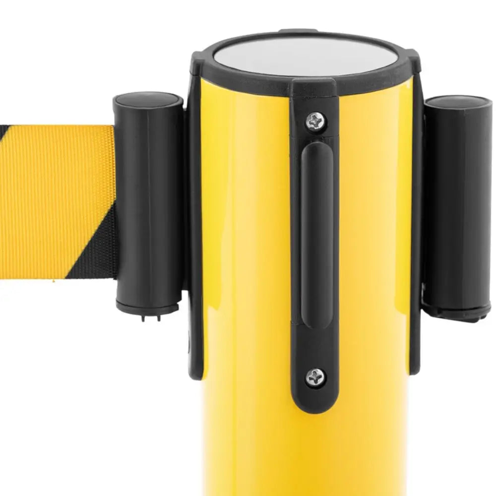 Gul og svart avsperringsstolpe fra siden, fokus på uttrekkbart bånd og sorte plastdetaljer.