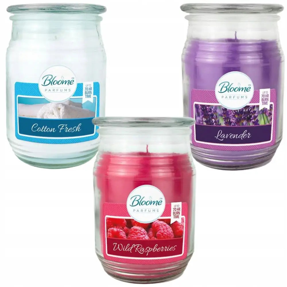 Stor duftlys i glass, tre farger med etiketter for ulike juledufter, sett forfra på rad.