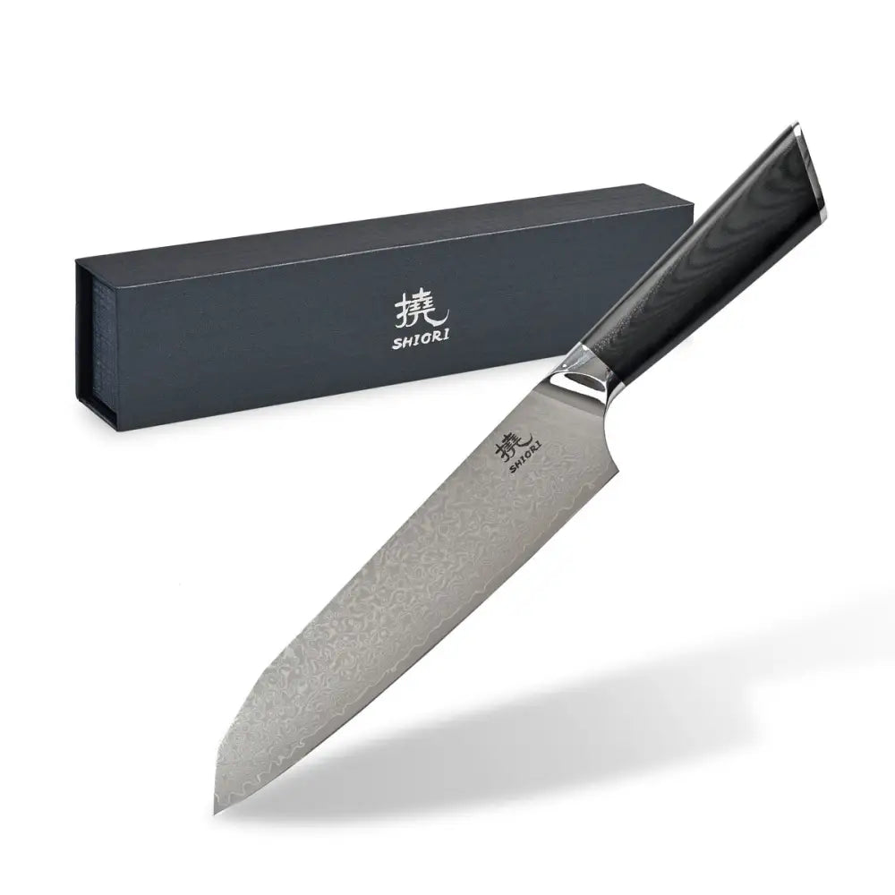 Santoku-kniv i damaskstål med mønstret blad og svart håndtak foran sort gaveeske med logo.