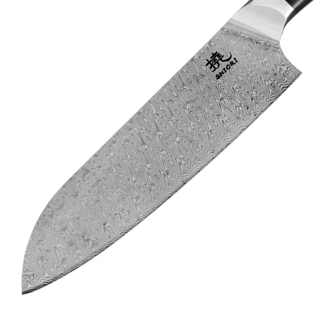 Stor Shiori Santoku damaskstålkniv, nærbilde av bladets bølgende mønster og tydelig logo ved G10-håndtaket.