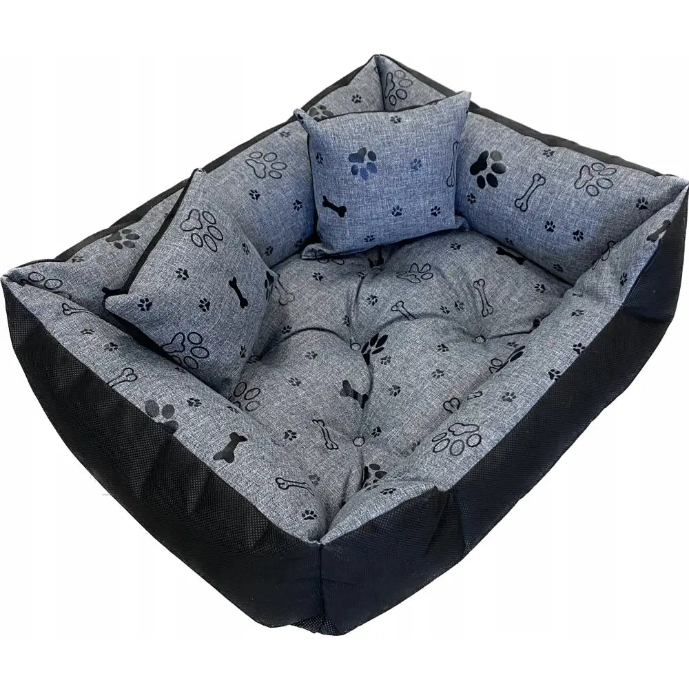 Stort hundeseng liggeunderlag 130 x 105 cm, skråvisning av grå seng med sorte pote- og beinmønstre samt to små puter.