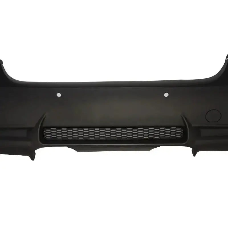 Bakre støtfanger til BMW 3 Serie E90 05-08 sedan i sort plast med gitterdetalj og runde utsparinger.