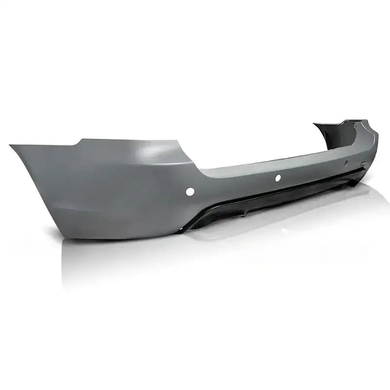 Bakfanger Bmw E61 Touring M-Pack PDC, grå med sensorhull og sort nedre kant, sett skrått bakfra.