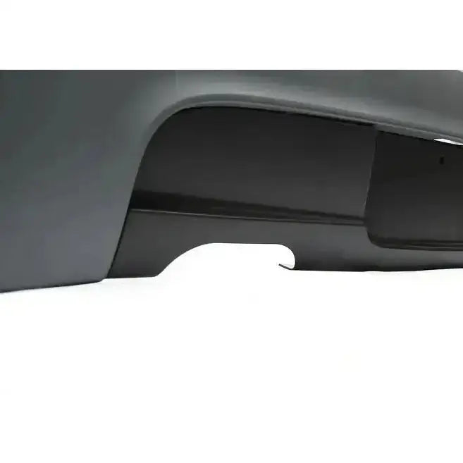 Bakre støtfanger til BMW E81/E87 M-Tech detaljbilde av svart og grå plast med avrundet utsparing.