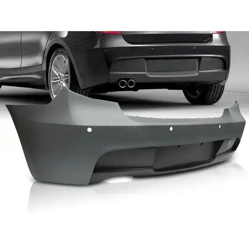 Støtfanger bak BMW E81/E87 M-Tech PDC i grå plast med sensorer, vist fra skrå vinkel foran svart bil.