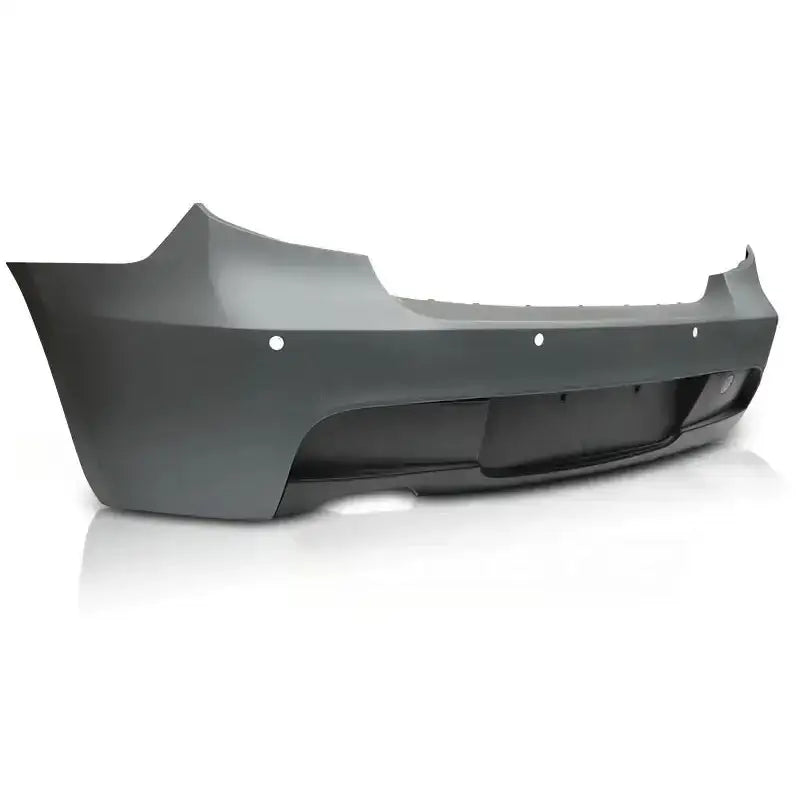 Bakfanger til BMW E81/E87 M-Tech PDC i matt grå plast med sensorhull og sorte detaljer, sett bakfra.