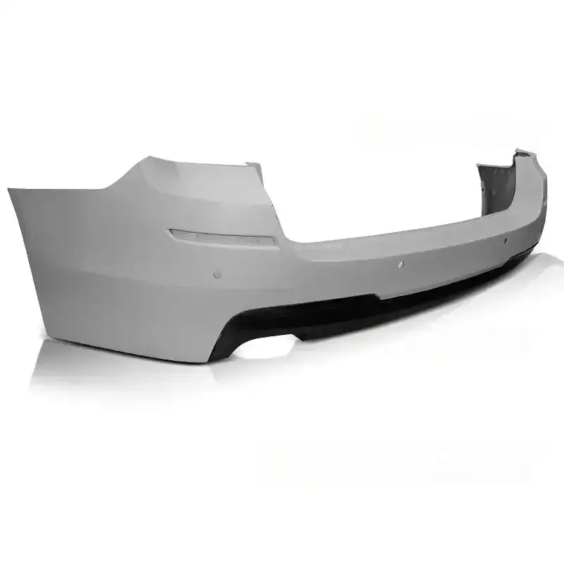 Bakfanger BMW F11 10-16 M-PAKIET PDC i lysegrå plast med svart kant, sett skrått bakfra.