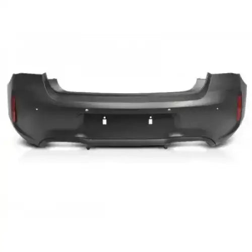 Bakfanger BMW F20/F21 LCI 15-18 M2 Look, sort plast med sensorutsparinger og refleksfelt sett forfra.
