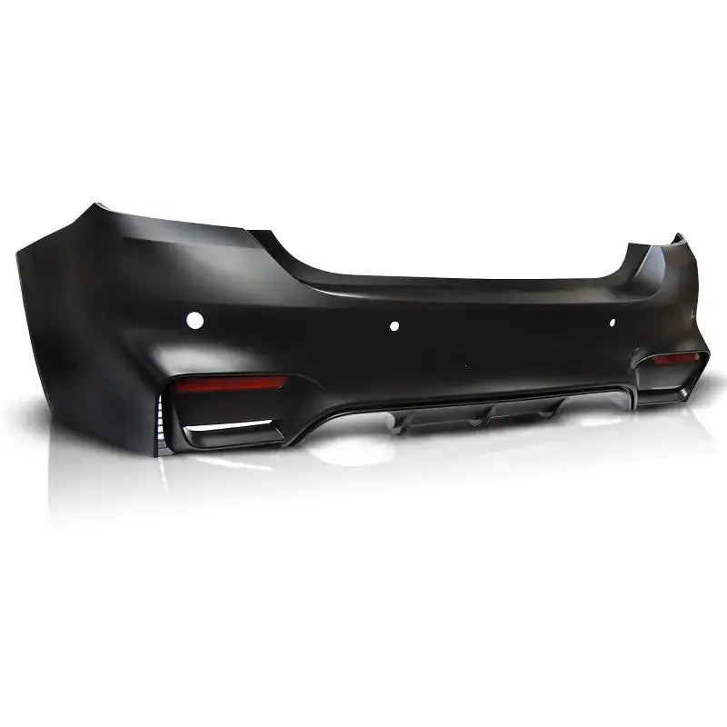 Bakfanger BMW F32/F33 M4 Style PDC i matt svart plast med sensorhull, refleks og diffuser, sett skrått bakfra.