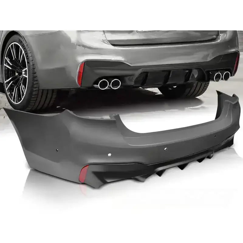 Støtfanger bak BMW G30 17- M5 Style PDC i svart plast med refleksfelt og luftkanaler sett skrått bakfra.