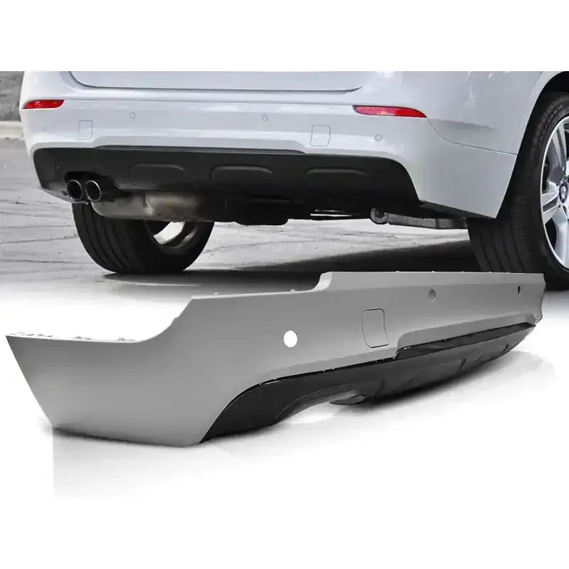 Støtfanger bak til BMW X1 E84 2009-2013 Diesel M-Pack PDC i grå og svart plast, sett fra siden.