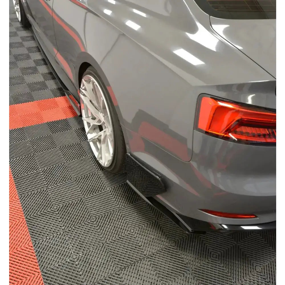 Bakfanger Audi S5 F5 sett skrått bakfra med sølvfelger, sideskjørt og baklys mot mønstret gulv.