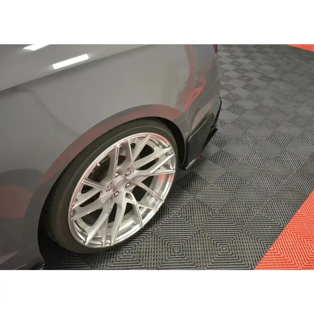 Bakre bumper til Audi S5 F5 vist fra siden, med sølvfelg på sort og rødt rutete gulv.