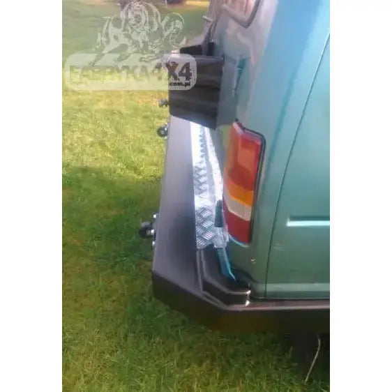 Bakre støtfanger Land Rover Discovery I Lang med svart metallfanger og aluminiumstrinn, sett skrått bakfra.
