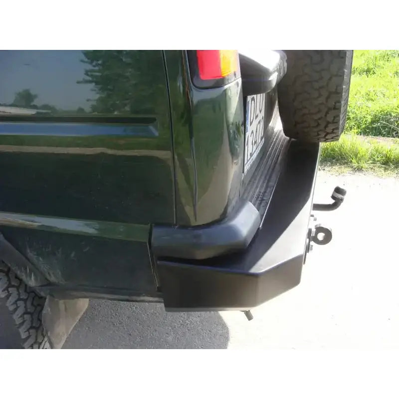 Bakfanger på Land Rover Discovery II med svart metallfanger, reservehjul og hengerfeste i dagslys.