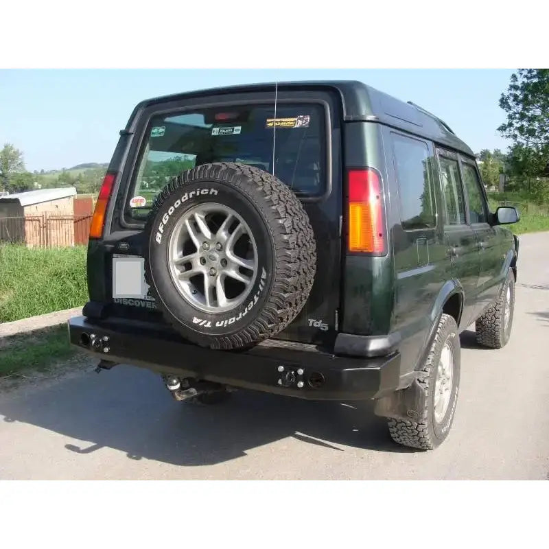 Bakre støtfanger Land Rover Discovery II montert på mørkegrønn SUV med reservehjul og terrengdekk.