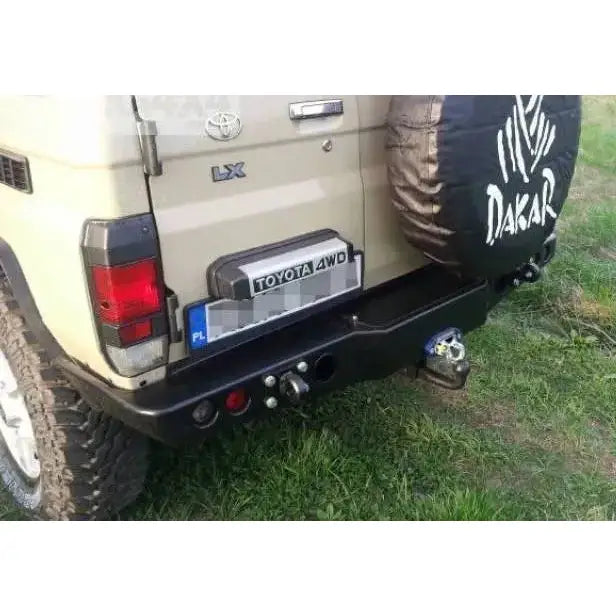 Støtfanger bak med vinsjplate på beige Toyota Land Cruiser J70 med tilhengerfeste og reservehjul.