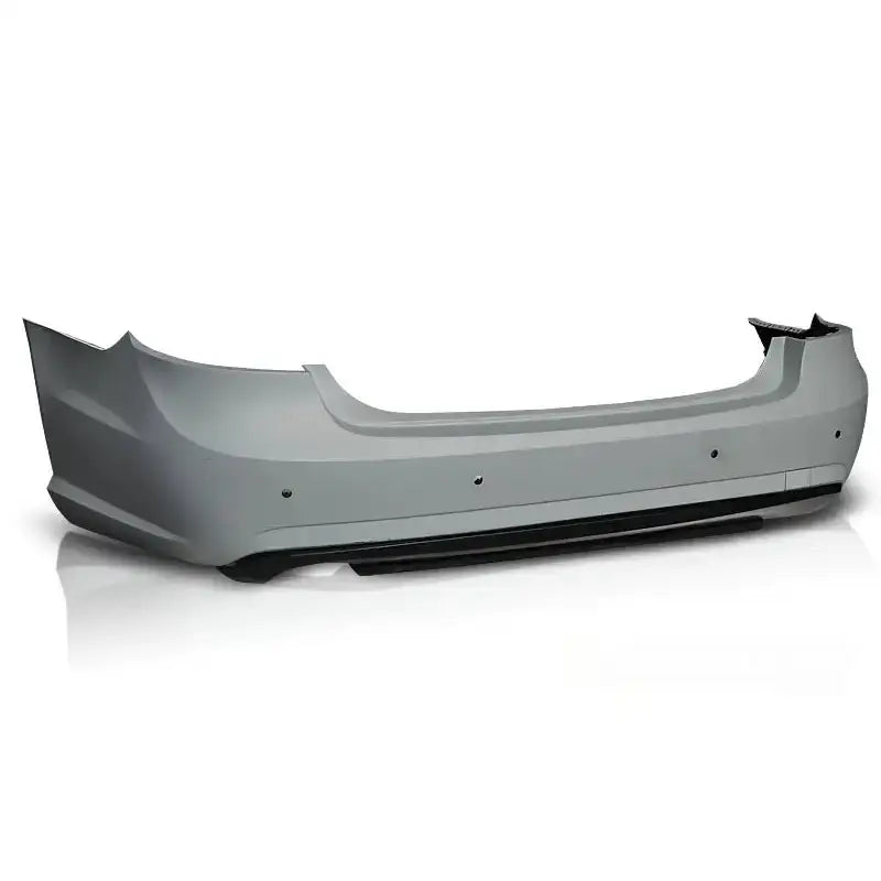 Bakfanger Mercedes W212 09-13 sedan AMG PDC i lyst grå plast med sorte detaljer, sett skrått bakfra.