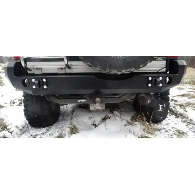 Støtfanger bak Mitsubishi Pajero II 90-00 i sort metall med reservehjul og hengerfeste, sett bakfra.