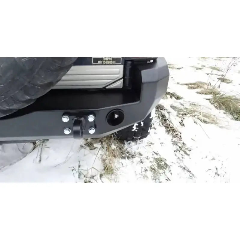 Bakfanger Mitsubishi Pajero II 90-00 montert på bil med reservehjul, sett skrått bak på snødekket bakke.