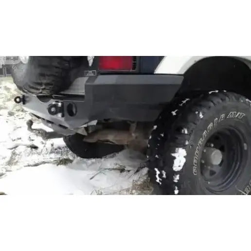 Bakre støtfanger til Mitsubishi Pajero II med sort metallfanger og reservehjul på snødekt underlag.