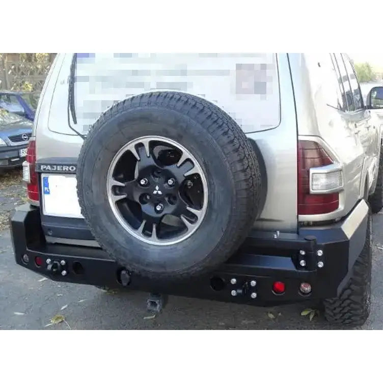 Støtfanger bak Mitsubishi Pajero III 00-06 i sort metall, montert på beige SUV med reservehjul bak.