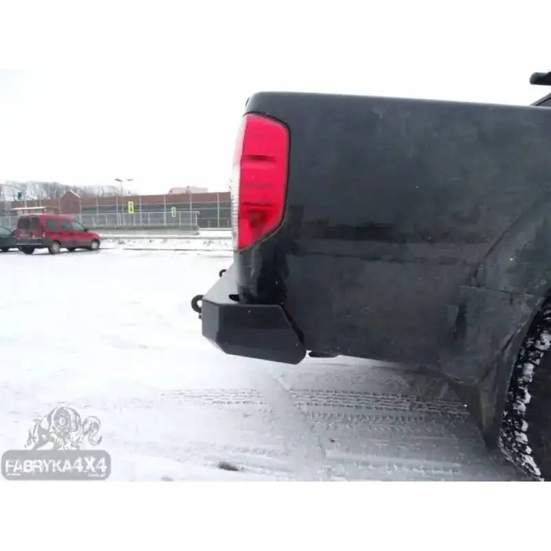 Bakre støtfanger på Nissan Navara D40 med svart metallfanger, sett skrått bakfra på snødekket bakke.