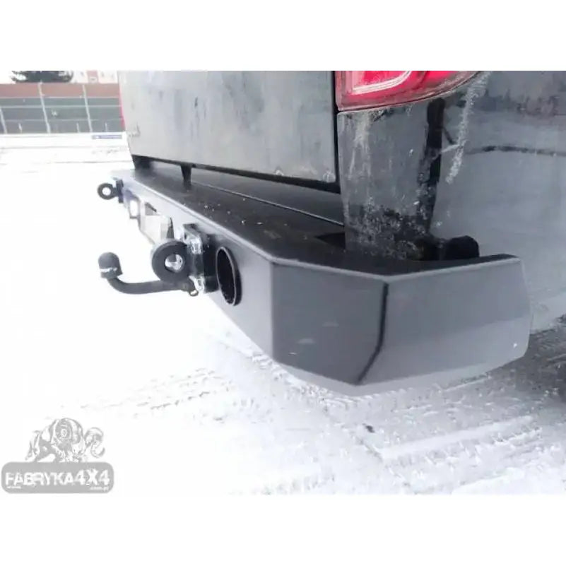 Bakstøtfanger til Nissan Navara D40 10-14 i sort metall med tilhengerfeste og krok, skrå bakside mot snø.