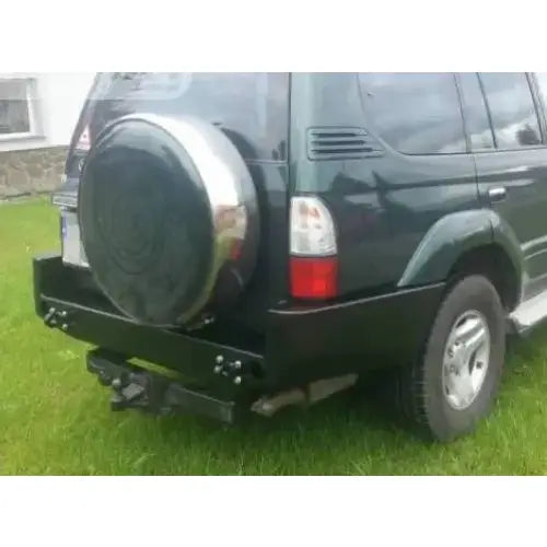 Støtfanger bak i sort stål på Toyota Land Cruiser J9 med reservehjul, sett skrått bakfra utendørs.