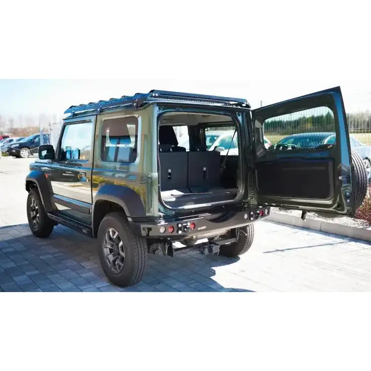 Bakstøtfanger på grønn Suzuki Jimny IV 1.5 sett bakfra med åpen bakdør og synlig bagasjerom.