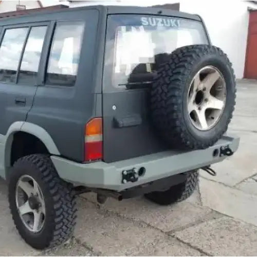 Støtfanger bak på Suzuki Vitara 2.0 V6 95-97, sett fra venstre bakside med reservehjul og terrengdekk.
