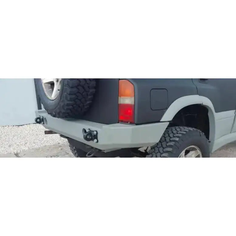 Bakfanger Suzuki Vitara 2.0 V6 95-97 med grå metall, baklys, kroker og reservehjul sett skrått bakfra.