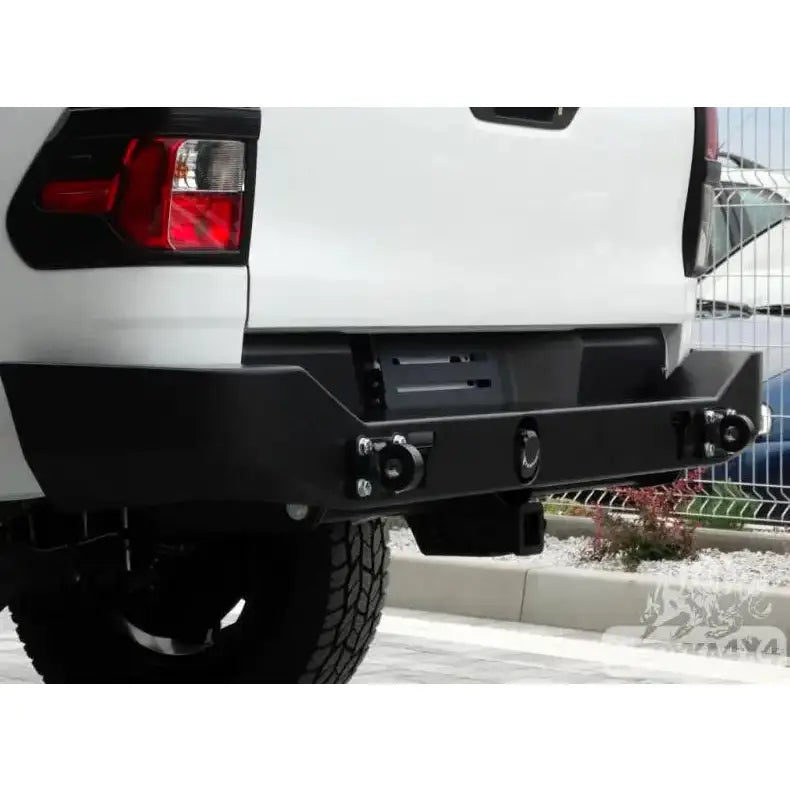 Bakre støtfanger Toyota Hilux Revo 16- sort metall med slepefeste, montert på hvit pickup bakfra.