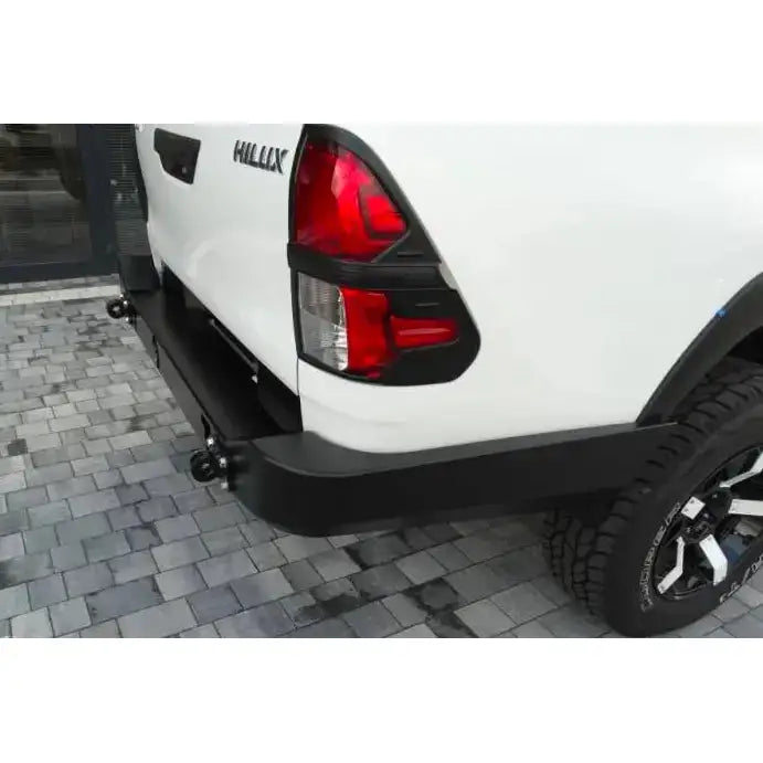 Bakstøtfanger til Toyota Hilux Revo 16- lang, sort metallfanger sett skrått bakfra med baklys og bakhjul.