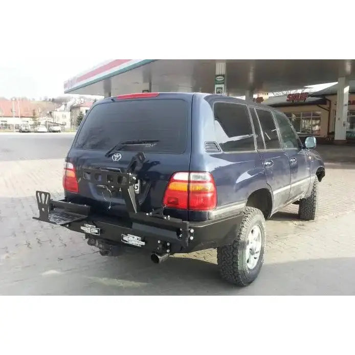 Bakstøtfanger til Toyota Land Cruiser J100 98-07 i sort metall med trinn og braketter, montert på blå SUV.