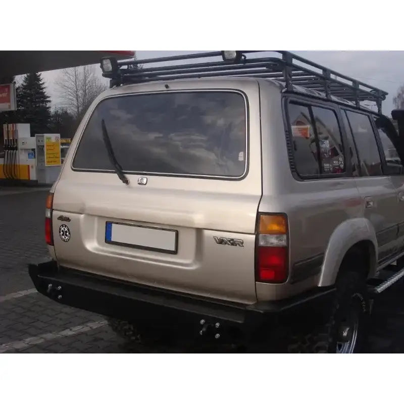 Bakfanger Toyota Land Cruiser LC80 montert på beige SUV med mørke ruter, takstativ og reservehjulsholder.