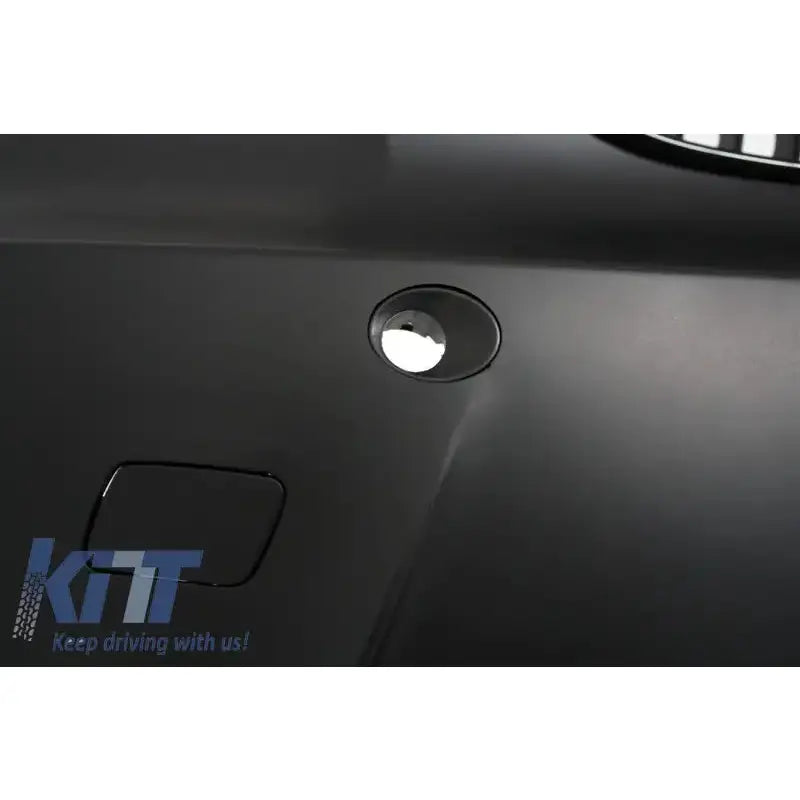 Frontbumper til BMW 1 Serie E88 nærbilde av svart matt plast med rund åpning og firkantet luke nederst.
